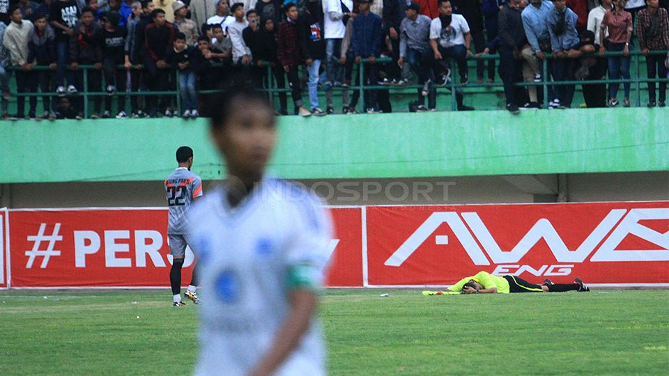 asisten wasit yang terkapar akibat terkena lemparan dari seorang suporter, dalam laga final Polda Jateng Cup antara Persis Solo menjamu tamunya PSIS Semarang. Copyright: &copy; Beny Raharjo/INDOSPORT